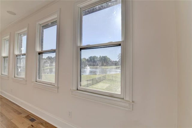 interior details featuring baseboards, ornamental molding, and wood finished floors