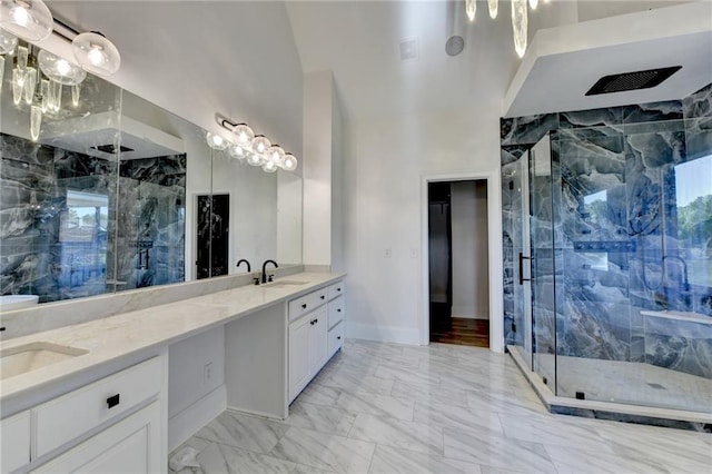 full bath with double vanity, a marble finish shower, a sink, and marble finish floor