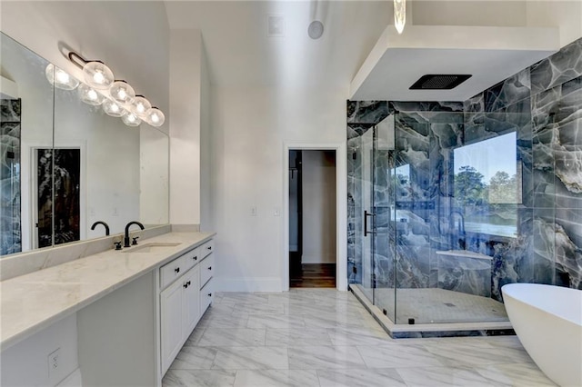 bathroom with a freestanding tub, a shower stall, marble finish floor, and vanity