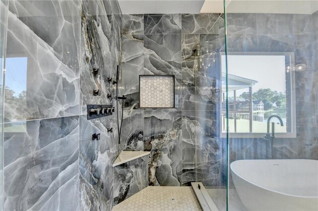 full bathroom with a walk in shower, a soaking tub, and tile walls