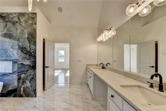 bathroom with double vanity, high vaulted ceiling, a sink, and marble finish floor