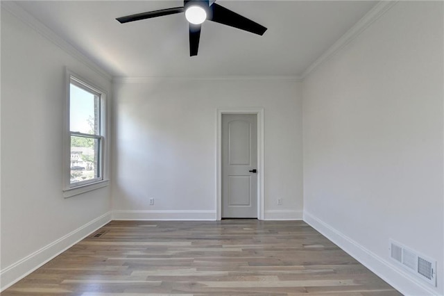 spare room featuring light wood-style floors, crown molding, a ceiling fan, and visible vents