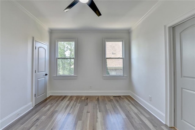empty room featuring crown molding, ceiling fan, baseboards, and light wood finished floors