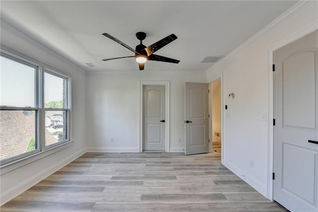 unfurnished bedroom featuring multiple windows, light wood-style flooring, and visible vents