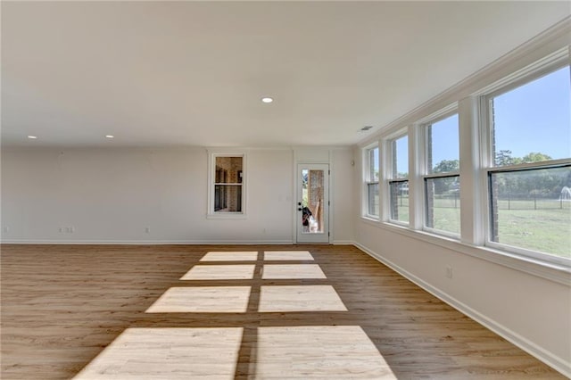 interior space with baseboards, recessed lighting, a wooden deck, and wood finished floors