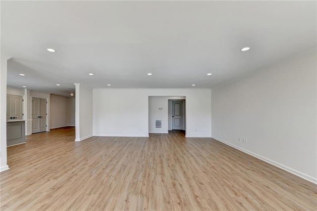 unfurnished living room with recessed lighting, baseboards, and light wood finished floors