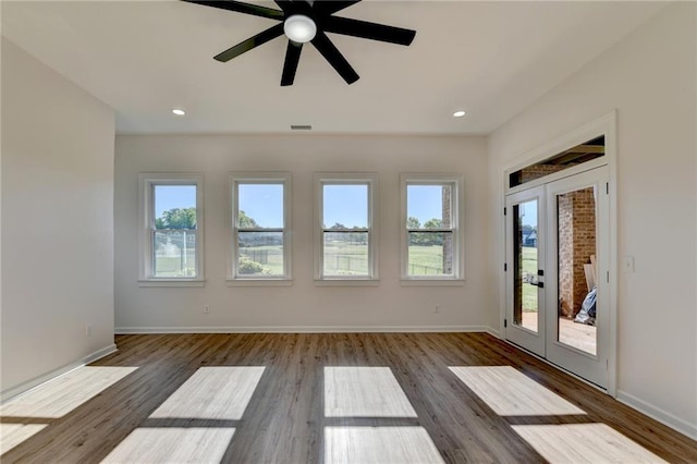 spare room with visible vents, baseboards, and wood finished floors