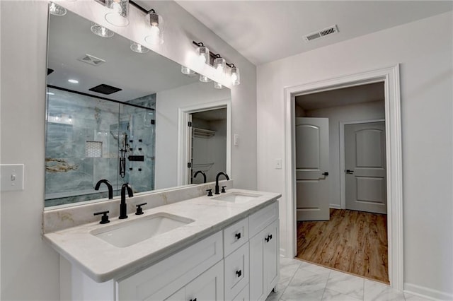 bathroom with a sink, a shower stall, and visible vents