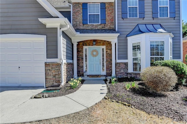 doorway to property featuring stone siding and a garage