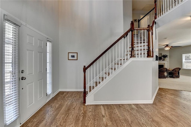 foyer with a high ceiling, wood finished floors, and stairs