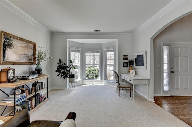 interior space featuring crown molding, visible vents, arched walkways, and carpet floors