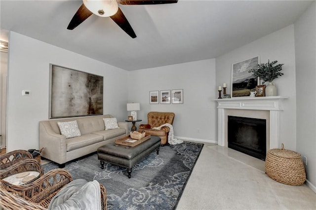 carpeted living area featuring a glass covered fireplace, a ceiling fan, and baseboards