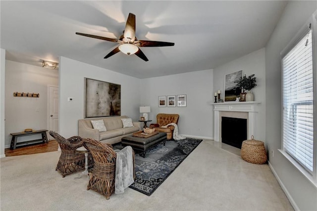 carpeted living room with a fireplace, baseboards, a wealth of natural light, and ceiling fan