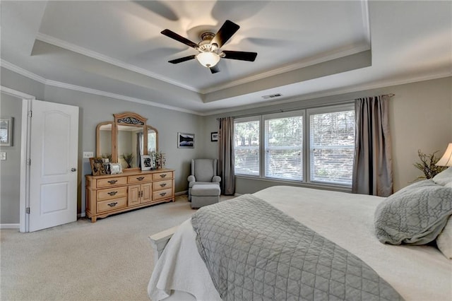 bedroom with visible vents, light colored carpet, crown molding, and a tray ceiling