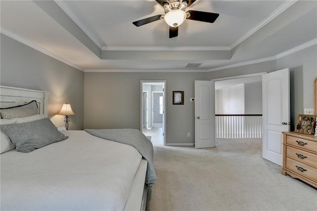 bedroom with a tray ceiling, light colored carpet, visible vents, and ornamental molding