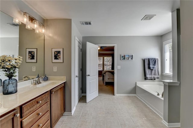 ensuite bathroom featuring visible vents, vanity, and a garden tub