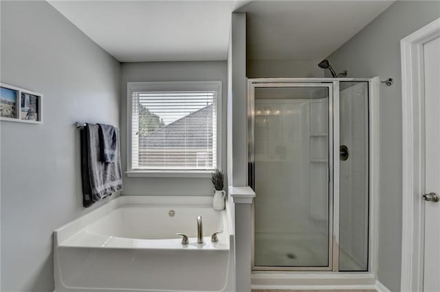 bathroom featuring a bath and a shower stall