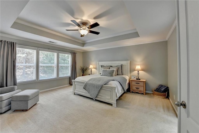 carpeted bedroom with a ceiling fan, a raised ceiling, baseboards, and ornamental molding