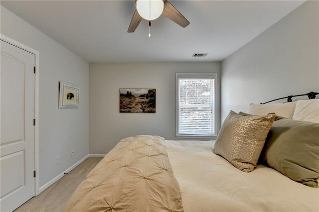 bedroom with light carpet, visible vents, a ceiling fan, and baseboards