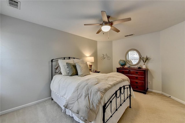 bedroom with visible vents, light carpet, and baseboards