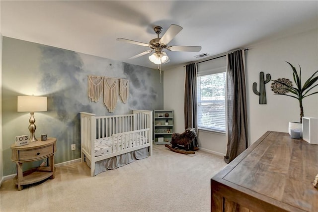 carpeted bedroom with visible vents, baseboards, and a ceiling fan