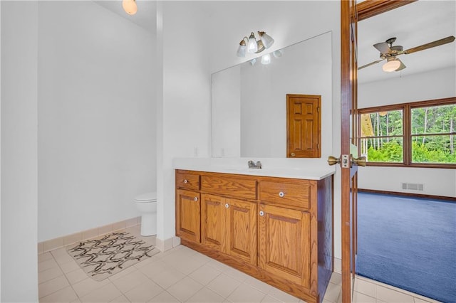 bathroom with tile patterned floors, vanity, toilet, visible vents, and a ceiling fan