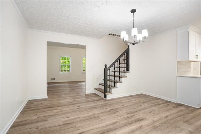 3021 Mills Ridge Dr, Canton, GA 30114 - unfurnished room with a chandelier, a textured ceiling, stairway, light wood finished floors, and baseboards