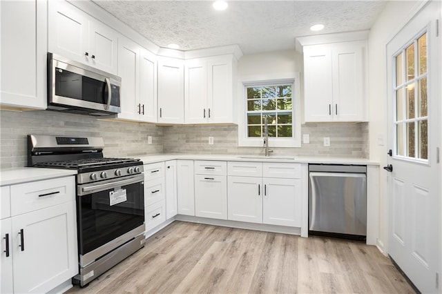 3021 Mills Ridge Dr, Canton, GA 30114 - kitchen with appliances with stainless steel finishes, a sink, a textured ceiling, light countertops, and white cabinets
