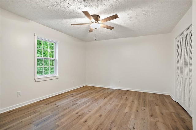 3021 Mills Ridge Dr, Canton, GA 30114 - unfurnished bedroom with wood finished floors, a closet, baseboards, a textured ceiling, and a ceiling fan