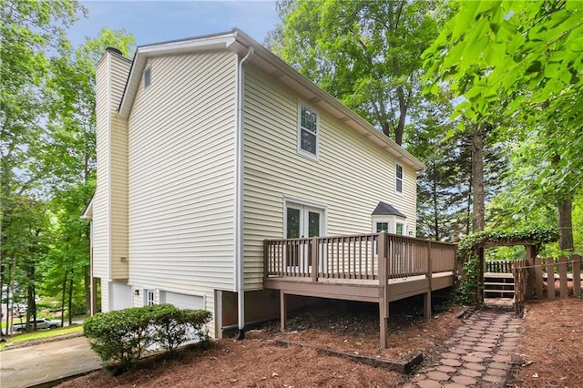 3021 Mills Ridge Dr, Canton, GA 30114 - rear view of property featuring a wooden deck, an attached garage, and a chimney