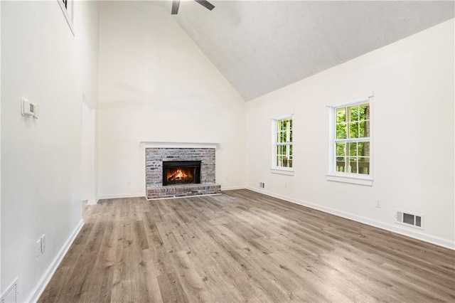 3021 Mills Ridge Dr, Canton, GA 30114 - unfurnished living room featuring high vaulted ceiling, wood finished floors, ceiling fan, baseboards, and a brick fireplace