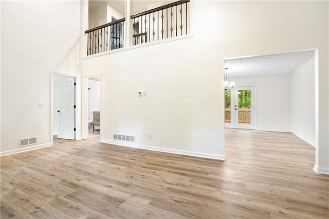 3021 Mills Ridge Dr, Canton, GA 30114 - unfurnished living room featuring a high ceiling, wood finished floors, baseboards, and a chandelier