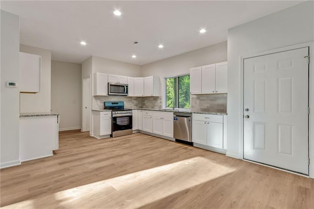 70 Wheeler Lake Path, Dallas, GA 30157 - kitchen with stainless steel appliances, white cabinetry, light wood-style floors, tasteful backsplash, and recessed lighting