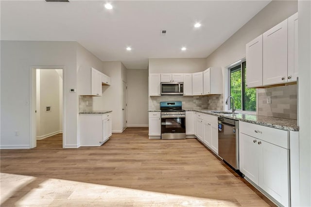 70 Wheeler Lake Path, Dallas, GA 30157 - kitchen with appliances with stainless steel finishes, a sink, white cabinets, light wood-style flooring, and recessed lighting
