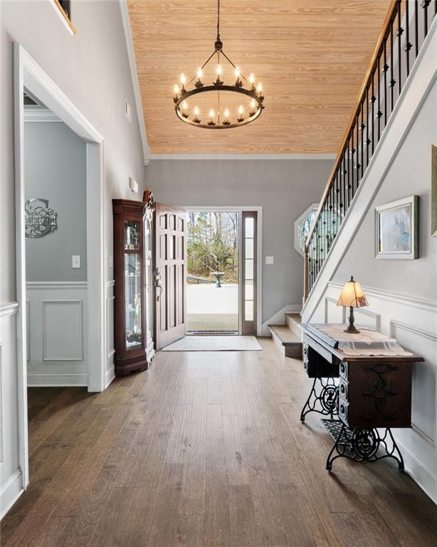 150 Crestview Rd, Jackson, GA 30233 - entryway featuring wooden ceiling, a chandelier, stairs, wood finished floors, and crown molding