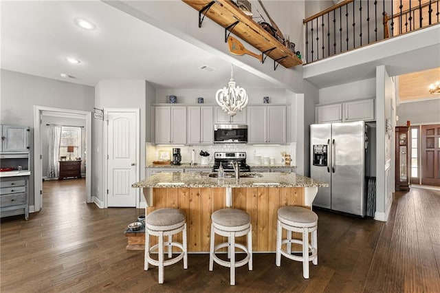 150 Crestview Rd, Jackson, GA 30233 - kitchen with appliances with stainless steel finishes, light stone countertops, a center island with sink, a kitchen breakfast bar, and a high ceiling