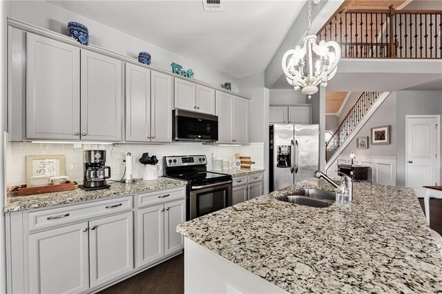 150 Crestview Rd, Jackson, GA 30233 - kitchen featuring appliances with stainless steel finishes, a sink, a chandelier, backsplash, and a kitchen island with sink