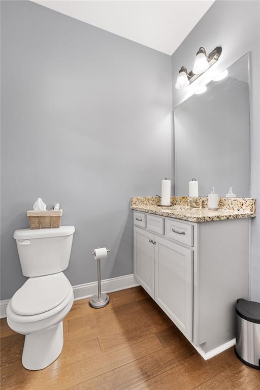 150 Crestview Rd, Jackson, GA 30233 - half bath featuring wood finished floors, baseboards, toilet, and vanity
