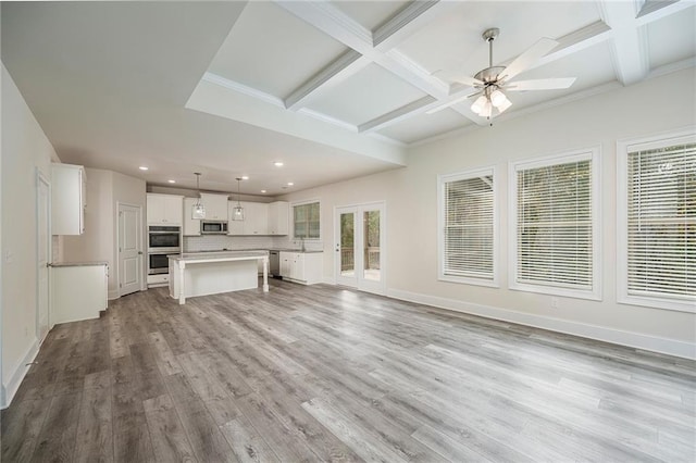 unfurnished living room featuring ceiling fan, coffered ceiling, beam ceiling, and light wood-type flooring