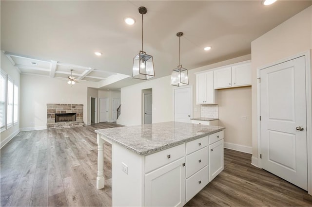 kitchen featuring a kitchen island, coffered ceiling, ceiling fan, white cabinets, and dark hardwood / wood-style flooring