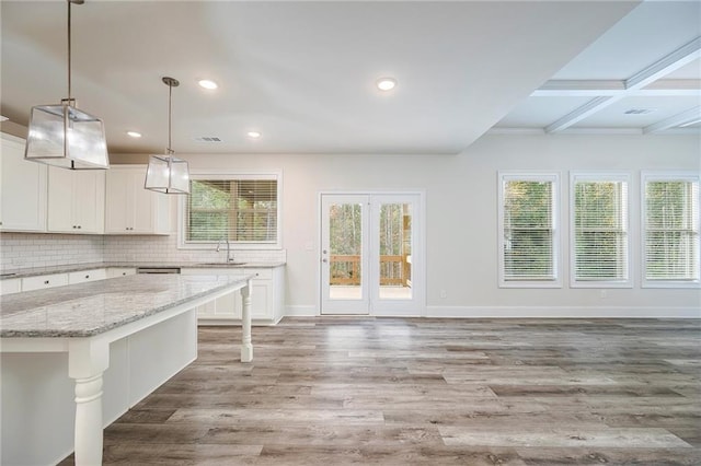 kitchen with light hardwood / wood-style flooring, white cabinets, and a wealth of natural light