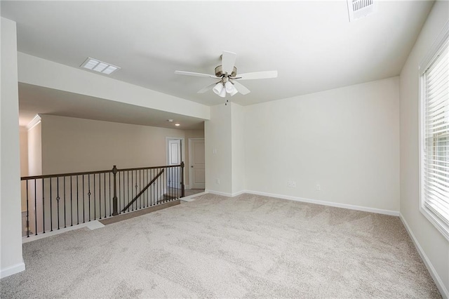 carpeted spare room featuring ceiling fan