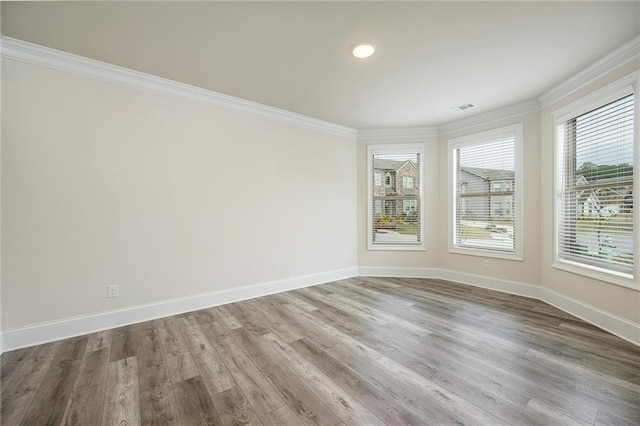 empty room with ornamental molding and wood-type flooring