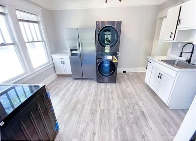 1127 Metropolitan Pkwy SW, Atlanta, GA 30310 - kitchen featuring stainless steel refrigerator with ice dispenser, a sink, estacked washer and dryer, baseboards, and light wood finished floors