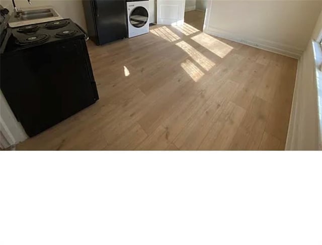 1127 Metropolitan Pkwy SW, Atlanta, GA 30310 - kitchen featuring washer / dryer, black appliances, light wood finished floors, and a sink