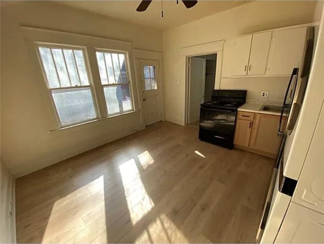 1127 Metropolitan Pkwy SW, Atlanta, GA 30310 - kitchen with black range, ceiling fan, light wood-style flooring, white cabinets, and light countertops