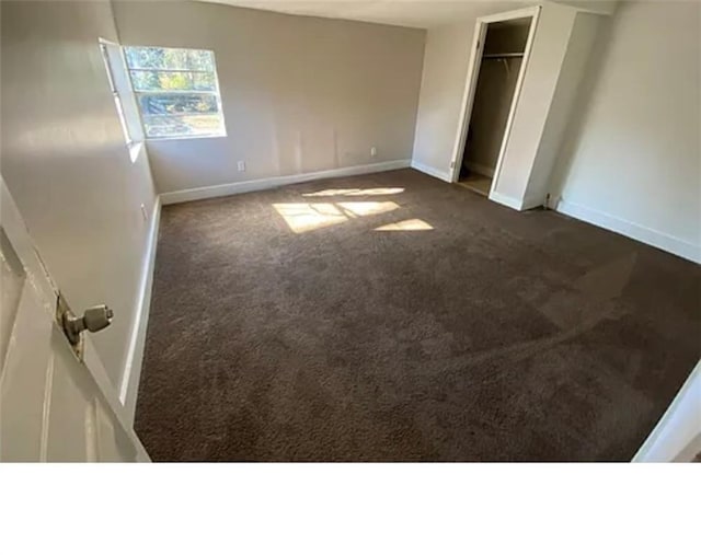 1127 Metropolitan Pkwy SW, Atlanta, GA 30310 - unfurnished bedroom featuring dark carpet, baseboards, and a closet
