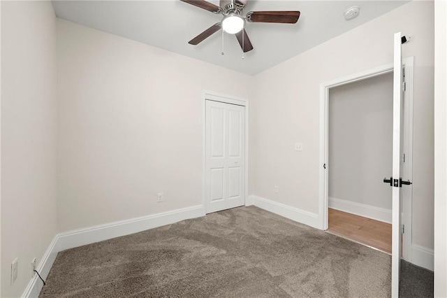 unfurnished bedroom featuring a closet, baseboards, carpet, and a ceiling fan