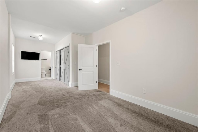 carpeted spare room with visible vents and baseboards