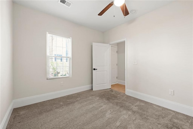 spare room featuring visible vents, carpet flooring, baseboards, and a ceiling fan